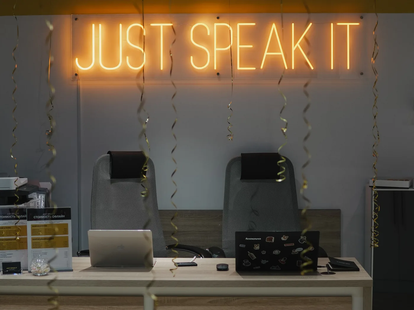 Ресепшен филиала JUST SPEAK IT в Астане с неоновой вывеской